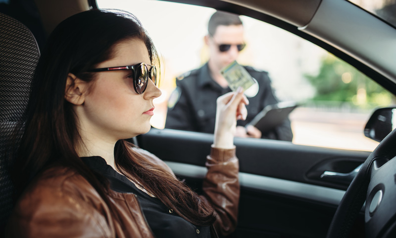 Miranda-Rights-Part-1-Blog Woman handing her ID to a police officer